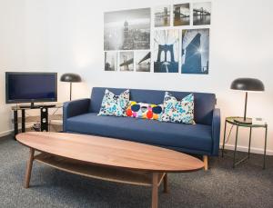 un soggiorno con divano blu e tavolino da caffè di MyCityHaven The KingsWeston - flexible home sleeps 7 a Bristol