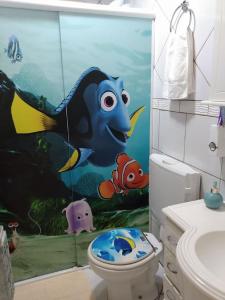 a bathroom with a fish themed shower curtain at Beto Pousada in Penha