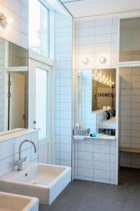 bagno bianco con lavandino e specchio di Sleep in Heaven a Copenaghen