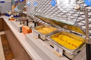 een buffet met dienbladen met eten erop bij Holiday Inn Express Hotel and Suites Saint Robert, an IHG Hotel in Saint Robert