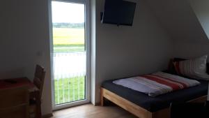 um quarto com uma cama e uma grande janela em Privatzimmer Popp-Hessenauer em Ansbach