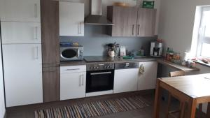 a kitchen with white cabinets and a microwave at Privatzimmer Popp-Hessenauer in Ansbach