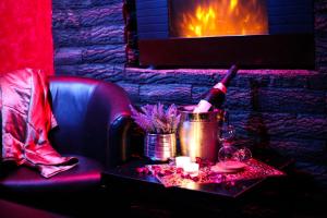 a table with a bottle of wine and a fireplace at Spa Secret in Belgrade