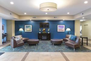 a waiting room with couches chairs and a fireplace at Candlewood Suites Odessa by IHG in Odessa