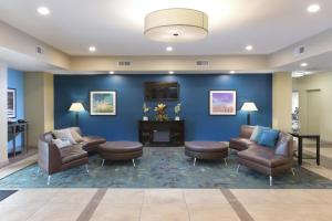 a waiting room with couches chairs and a fireplace at Candlewood Suites Odessa, an IHG Hotel in Odessa