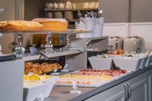 a kitchen counter filled with lots of different types of food at Dedo Boutique Hotel in Florence