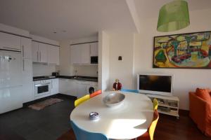 a living room with a table and a kitchen at El Mirador de Oviedo in Oviedo