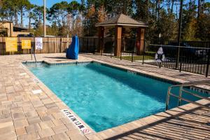 a swimming pool with a gazebo in a yard at Candlewood Suites - Jacksonville - Mayport, an IHG Hotel in Jacksonville