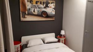 - une chambre avec un lit et une photo de voiture de course dans l'établissement L'appart promenade de 4 heures, à Spa