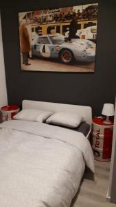 - une chambre avec un lit et une photo de voiture de course dans l'établissement L'appart promenade de 4 heures, à Spa