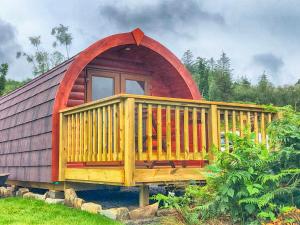 een kleine hut met een groot terras aan de buitenkant bij Tarbert Holiday Park in Tarbert