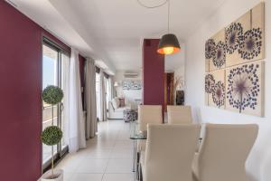 a dining room with white chairs and purple walls at AT Suites in Córdoba