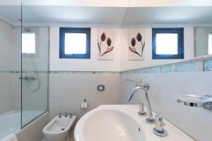 a bathroom with a sink and a toilet and windows at AT Suites in Córdoba