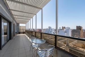 a balcony with two chairs and a table on a building at AT Suites in Córdoba