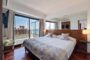 a bedroom with a large bed with a large window at AT Suites in Córdoba