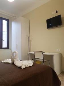 una camera con letto, scrivania e TV di Hotel Emmy a Milano