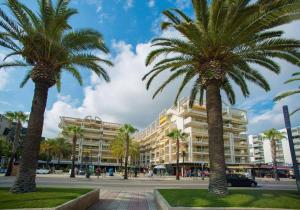 two palm trees in front of a building at Novelty I in Salou