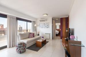 a living room with a couch and a large window at AT Suites in Córdoba