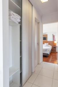 a hallway with a mirror and a bedroom with a bed at AT Suites in Córdoba