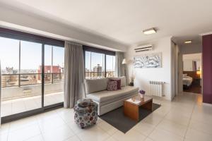 a living room with a couch and a large window at AT Suites in Córdoba
