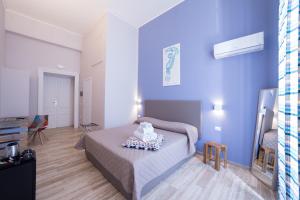 1 dormitorio con cama y pared azul en PC Boutique H Loggia, by ClaPa Group, en Nápoles