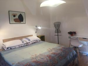 a bedroom with a bed and a desk and a lamp at Panoramic view near the beach in Portotož+P in Portorož