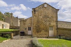 an external view of a brick building with a patio at Harewood Estate Cottages in Harewood