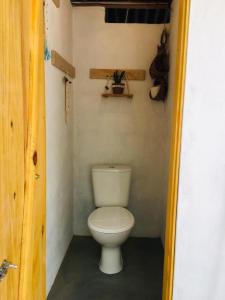 a bathroom with a toilet in a small room at Kombi Hostel Camping in Vale do Capao
