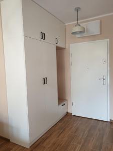 Habitación con armarios blancos y puerta. en LAGUNA Apartament 23 Willa Leśna en Polanica-Zdrój
