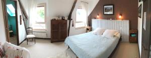 - une chambre avec un lit blanc et 2 fenêtres dans l'établissement Les Petits Gallais, à Saint-Carreuc