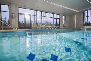 a large swimming pool with blue water in a building at Lodge Kohler in Green Bay