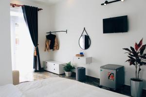 a bedroom with a bed and a tv on a wall at Sally Villa Homestay in Da Lat