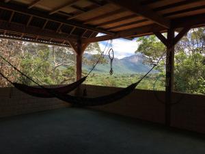 a hammock in a room with a view of a mountain at Kombi Hostel Camping in Vale do Capao
