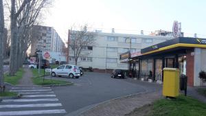 una calle con un coche blanco estacionado frente a un edificio en Chambre 1 PERSONNE et STUDIO 1 personne Avec Entrée Libre et Salle de Bain Privée, en Colomiers