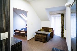 1 dormitorio con 1 cama, 1 sofá y 1 silla en Hotel Sulbin, en Garwolin