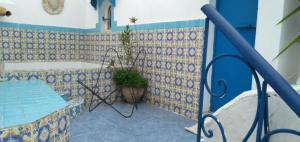 a bathroom with blue and white tiles and a bath tub at Dar Warda in Bizerte