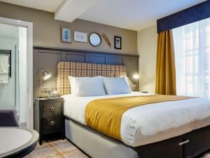 a bedroom with a large bed and a window at The Feathers Hotel in Ludlow