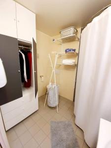 La salle de bains est pourvue d'un rideau de douche et d'un placard blanc. dans l'établissement Au Beaujolais Saint Jean, à Belleville-sur-Saône