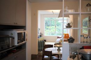 uma cozinha e sala de estar com uma mesa e um micro-ondas em Design e sofisticação em Higienópolis em São Paulo