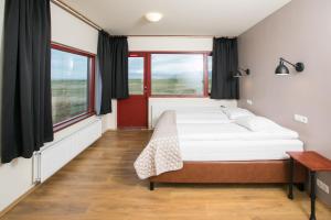 a bedroom with a bed and two windows at Hotel Langaholt in Langaholt