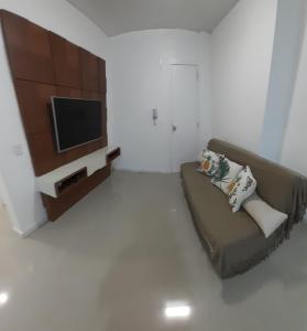 sala de estar con sofá y TV de pantalla plana en Apartamento 2 dormitório praia de Bombas, en Bombinhas