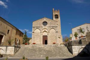 a church with a tower and stairs in front at La Torre in Asciano