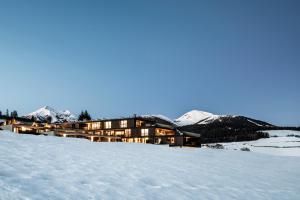 a building on top of a snow covered mountain at Aparthotel Panorama Living Dolomites in Maranza