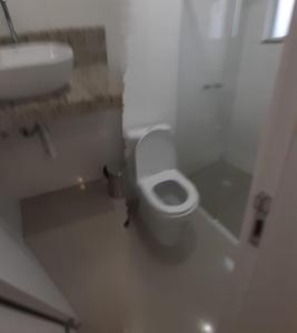 y baño con aseo blanco y lavamanos. en Apartamento 2 dormitório praia de Bombas, en Bombinhas