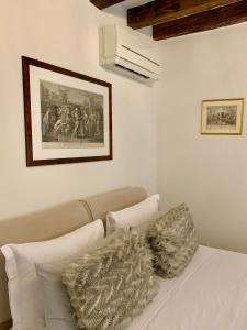 a white bedroom with a couch and a picture on the wall at B&B Fortuny in Venice