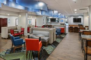 una sala de espera con mesas y sillas y una cafetería en Holiday Inn Express Atlanta Airport-College Park, an IHG Hotel en Atlanta
