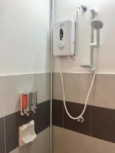 a shower in a bathroom with a toilet paper dispenser at ORKED BELLINA, 3 Bedroom apartment, near Pantai Batu Burok, NETFLIXWIFIYOUTUBE in Kuala Terengganu