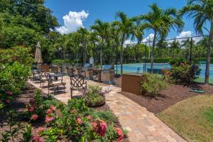 a patio with tables and chairs next to a pool at Loggerhead Cay #112 in Sanibel