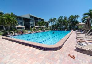 a large swimming pool with chairs and a hotel at Loggerhead Cay #112 in Sanibel