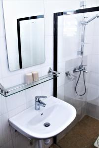 a white bathroom with a sink and a mirror at Bungalow Beach Hotel in Serekunda